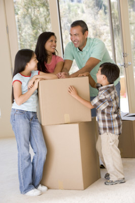 Family with boxes in new home smiling